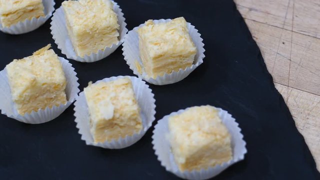 Many mini Napoleon cakes top view on a black plate