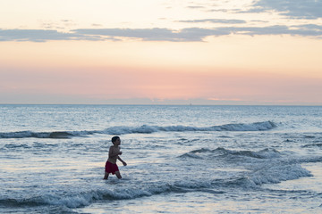 Fototapeta na wymiar atardecer en el mar puesta de sol niños nenes