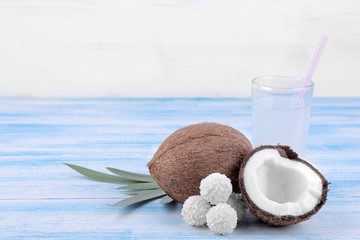 Coconut with coconut sweets and coconut milk on a blue wooden background
