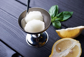 2 balls of homemade Lemon sorbet ice cream in metal bowl on black wooden background. Tasty summer dessert - obrazy, fototapety, plakaty