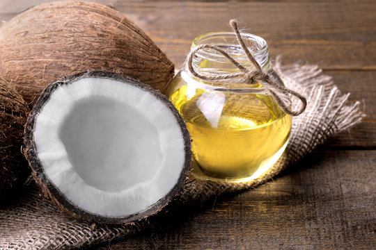 Coconut with coconut oil on a brown wooden background