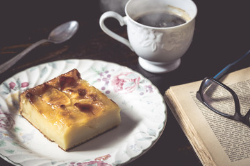Sweet homemade apple cake and coffee. Breakfast and reading on rustic wooden table.