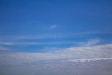 Small bubble flying on blue sky with clouds