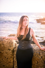 Pink Evenings by the Sea. A female caucasian model next to the california coast at sunset. Pink accents for a romantic feeling