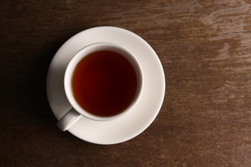 White tea glass on wooden table top corner. Have space