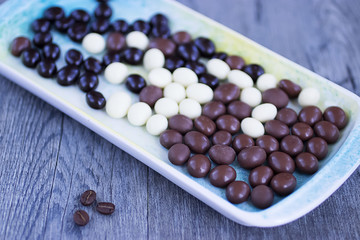 Grains of coffee in glaze of white, milky, and dark chocolate.