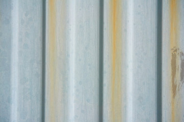 An old metal rippled wall with rusty streams. Abstract background.