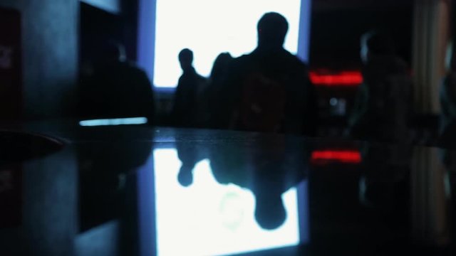 Silhouette зeople leave auditorium during the movie performance.