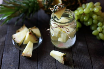 water in jar with pineapple  on wooden background