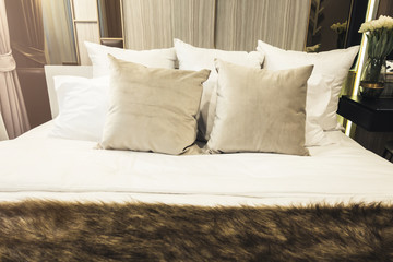 Bed maid-up with clean white pillows and bed sheets in beauty bedroom.