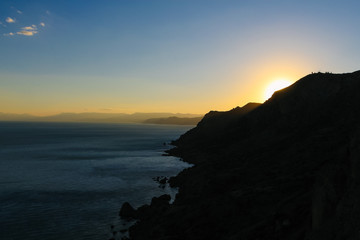 Fototapeta premium Sea and Mountains landscape on Sunset at Cape Meganom, the east coast of the peninsula of Crimea. Beautiful nature, Colorful background.