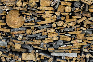 Wood chopped firewood stacked on the stack. Background of firewood stack. Stack of chopped firewood prepared for winter. Pile of chopped fire wood, background.