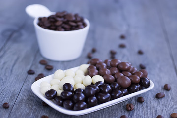 Grains of coffee in glaze of white, milky, and dark chocolate.