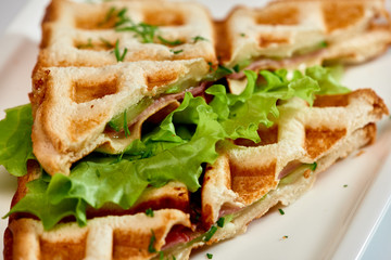 Waffle sandwich with ham and salad./Crispy sandwich with ham and salad. Breakfast.