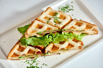 Waffle sandwich with ham and salad./Crispy sandwich with ham and salad. Breakfast.