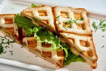 Waffle sandwich with ham and salad./Crispy sandwich with ham and salad. Breakfast.