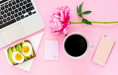 Feminine Pink Workspace Flat Lay with Computer, Phone, Avocado Toast and Coffee on Desk Top