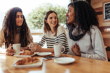 Friends sitting in a cafe and talking