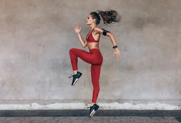 Fotobehang Sportswoman jumping and stretching © Jacob Lund