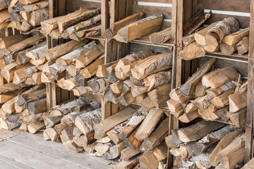 Holzscheite lagern zum Trocknen in Holzkisten an einer Wand