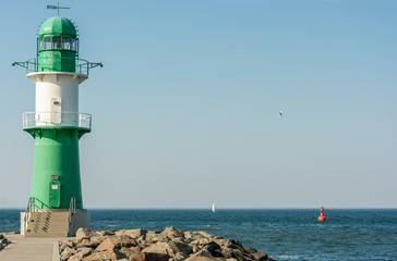Fototapeta na wymiar Grün weißer Leuchtturm an der Hafeneinfahrt in Warnemünde