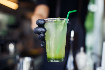 Handing cucumber lemonade in plastic cup from foodtrack