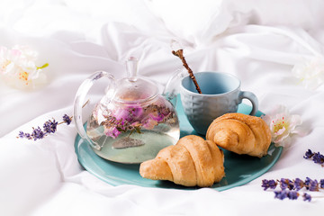 Breakfast in bed concept - french croissants with a cup of tea.