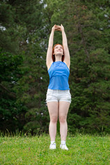 a girl is  doing sports exercises in the park