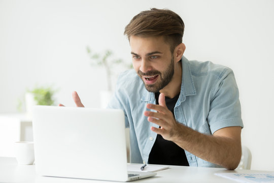 Excited casual happy male worker looking at laptop screen, gaining profit, satisfied with successful investment, winning lot of money in lottery, getting promoted. Concept of reward, luck, achievement