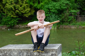 a boy with a bamboo stick