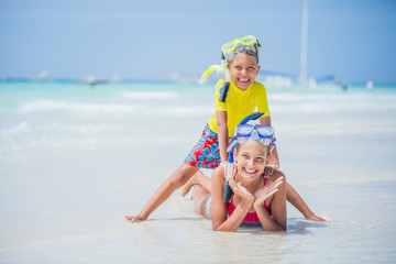 Brother and sister playing on the beach during the hot summer vacation day.