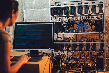 Programmer adjusting cryptocurrency mining rig to optimal operational settings