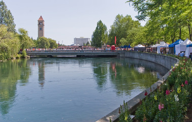 Spokane River in Riverfront Park with Clock Tower flowers, people, bridge and vendors