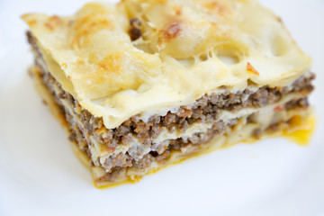 Traditional lasagne on a white plate. Side view. Closeup.