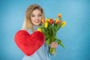 Woman holds tulips and red heart