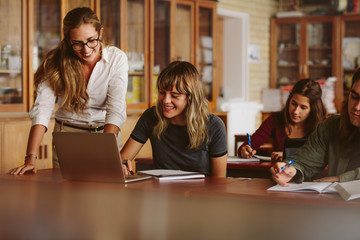 Teacher helping her student at high school