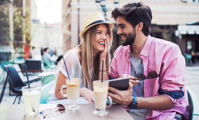 Young couple sitting in the cafe and having fun with tablet. Dating, relationships, love, romance, lifestyle, technology