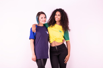 Portrait de deux jeunes supportrices de l'équipe du Brésil et de l'équipe de France fraternisant