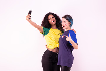 Selfie de deux jeunes supportrices de l'équipe du Brésil et de l’équipe de France  - obrazy, fototapety, plakaty