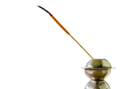 Burning orange incense joss stick on the stand in white background