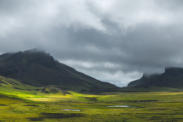 Wild nature mountain landscape with a spots of light.