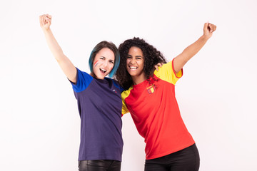 Portrait de deux jeunes supportrices de l'équipe d'Espagne et de l'équipe de France fraternisant - obrazy, fototapety, plakaty