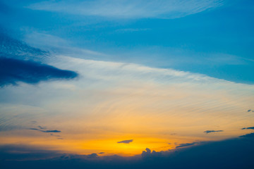 Beautiful early blue cloudy sky with orange sunlight. Atmospheric cobalt background of colorful sunrise with dense clouds and bright yellow sunny light for copy space. Cyan heaven above clouds.