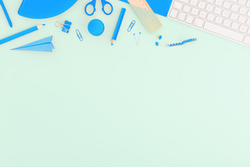 School flat lay design. Back to school concept blue supplies over pastel green background.