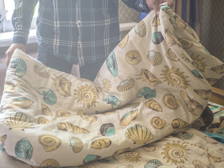 close up person making a bed with blanket