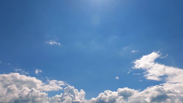 moving clouds on the blue sky lit with sunlight
