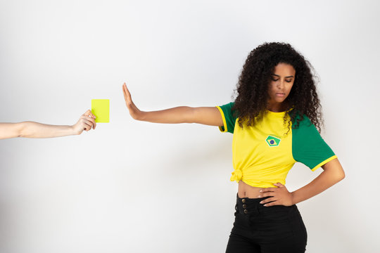 Portrait d'une jeune supportrice de l'équipe du Bresil prenant un carton jaune