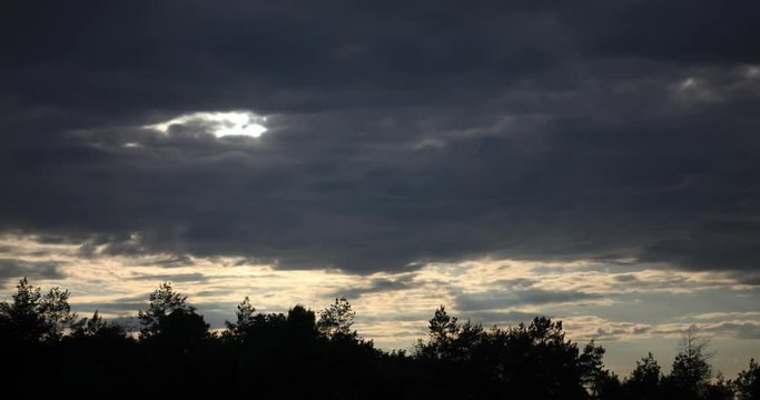 Quickly floating dark clouds in cloudy twilight and sunset
