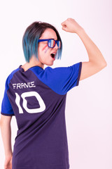 Portrait d'une jeune supportrice de l'équipe de France de football portant des lunettes tricolore