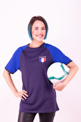 Portrait d'une jeune supportrice de l'équipe de France de football tenant un ballon dans ses mains - obrazy, fototapety, plakaty